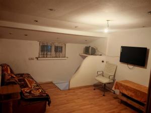 a bedroom with a bed and a chair and a tv at Apartament muncitori in Bacău