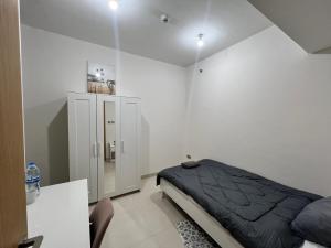 a white bedroom with a bed and a cabinet at Cozy Room In Abu Dhabi Reem island Near to Galeria Mall in Abu Dhabi