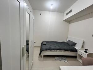 a small bedroom with a bed and a glass door at Cozy Room In Abu Dhabi Reem island Near to Galeria Mall in Abu Dhabi