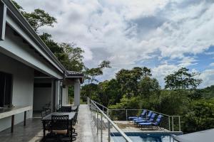 a balcony of a house with chairs and a swimming pool at Cayo Casa Grande Modular Villa with Pool, Gym & Valley Views in Santa Elena