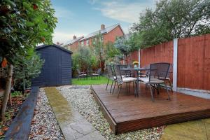 a wooden deck with a table and chairs on it at Spacious 4BR Townhouse, Sleeps 9, Fast WIFI, FREE PARKING, Contractor friendly in Colchester