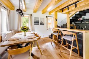 a kitchen and dining room with a wooden table and chairs at Vila Sněženka in Horní Planá
