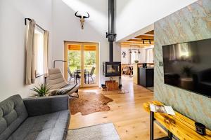 a living room with a couch and a tv at Vila Sněženka in Horní Planá