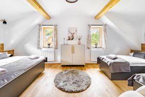 a attic bedroom with two beds and a rug at Vila Sněženka in Horní Planá