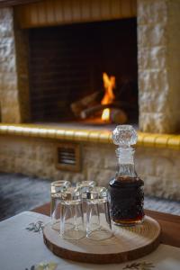 a bottle of whiskey and three wine glasses on a table at Artemis Mezonetes in Kalavrita