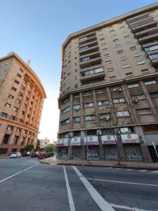 a tall building on a city street with a parking lot at Libertador 8 MVD in Montevideo