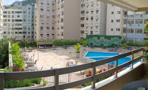 a balcony with a swimming pool and buildings at Apart Novidade do verao in Rio de Janeiro