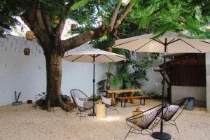 カンクンにあるThe Boat House Cancunのパティオ(テーブル、椅子、パラソル付)