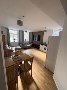 a kitchen and living room with a table and chairs at Pentwyn avenue apartment in Mountain Ash