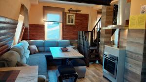 a living room with a blue couch and a table at Apartments Artic in Jahorina