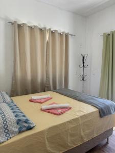 a bed with two towels on top of it at Recanto do Bosque in Magé