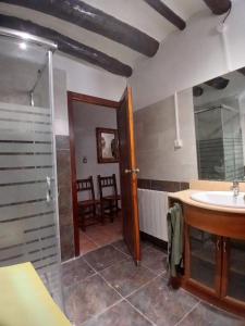 a bathroom with a sink and a mirror and a shower at Casa Rural Forcén in Lumpiaque +8 photos