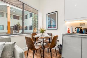 a kitchen and dining room with a table and chairs at The Cosy Luxe in Slough