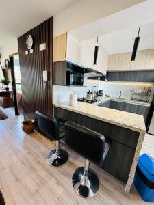 a kitchen with two black chairs and a counter at Departamento Centrico en Cusco in San Antonio