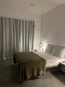 a bedroom with a large bed in front of a window at Maré alta in Guriú