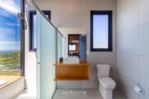 Un baño con lavabo, inodoro y espejo. en Cabaña romántica cerca de Florianópolis VST038, en São Paulo dos Pinhais