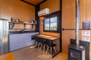 Cabana romântica com vista na serra VST038 في São Paulo dos Pinhais: مطبخ مع طاولة وكراسي في مطبخ