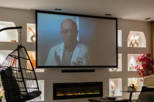 a large screen with a man on it in a living room at Appartement avec salle de cinema in Agadir