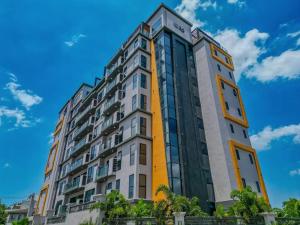 a tall yellow and white building against a blue sky at Rooftop Pool Condo in Kingston in Kingston