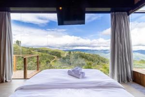 Charmoso chalé com lareira e hidro! VST034 في São Paulo dos Pinhais: سرير في غرفة ذات نافذة كبيرة