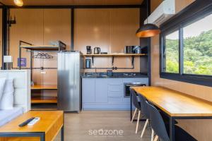 Charmoso chalé com lareira e hidro! VST034 في São Paulo dos Pinhais: مطبخ وغرفة طعام مع طاولة خشبية