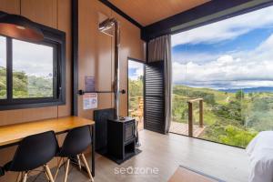 a room with a bed and a desk and chairs at Charmoso chalé com lareira e hidro! VST034 in São Paulo dos Pinhais