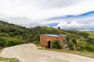 a small house on top of a hill with a ramp at Charmoso chalé com lareira e hidro! VST034 in São Paulo dos Pinhais