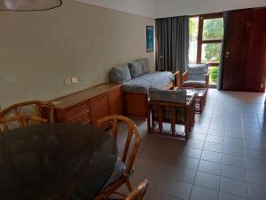 una sala de estar con un sofá, una mesa y sillas en Tiempo Compartido Clermont Pinamar, en Pinamar