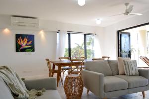 ein Wohnzimmer mit Sofa und Tisch in der Unterkunft Beachfront 3-Bed with Pool & Stunning Ocean Views in Trinity Beach + 22 Fotos