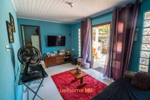 een woonkamer met blauwe muren en een rood tapijt bij Sitio com piscina e lazer completo em Mongagua in Agenor de Campos