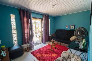 een woonkamer met een zwarte bank en een rood tapijt bij Sitio com piscina e lazer completo em Mongagua in Agenor de Campos +39 foto's