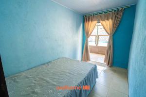a blue bedroom with a bed and a window at Sitio com piscina e lazer completo em Mongagua in Agenor de Campos