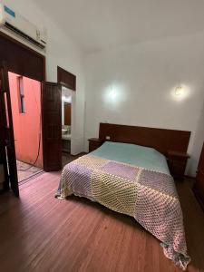 a bedroom with a bed and a wooden floor at 9deJulio90 in Colón