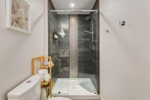 a bathroom with a shower with a toilet and a sink at 2 Storey Penthouse Panoramic Views Parking Stampede in Calgary