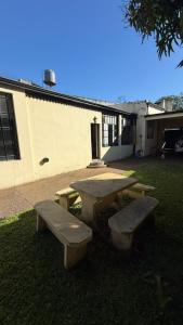 a picnic table and two benches in front of a building at 9deJulio90 in Colón