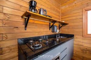 une cuisine avec une cuisinière et un comptoir dans l'établissement Cabana incrível p/ casais na região serrana VST011, à São Paulo dos Pinhais