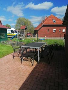 a table and chairs on a patio with a playground at Käpt'n Brandt in Osteel +6 photos
