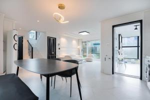 a dining room and living room with a table and chairs at Domostay in Seogwipo
