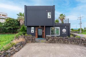 a black house with a black facade at Domostay in Seogwipo