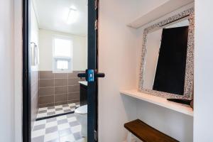 a bathroom with a mirror and a toilet at Domostay in Seogwipo +34 photos