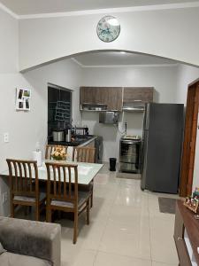 马瑙斯Casa com suite bem localizada的配有桌椅和冰箱的厨房