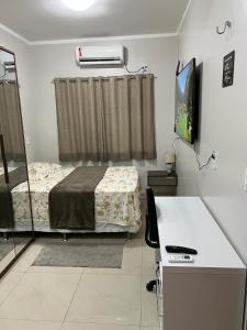 马瑙斯Casa com suite bem localizada的一间设有床铺和电视的房间