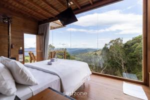 une chambre avec un lit et une grande fenêtre dans l'établissement Cabana romântica com vista na serra VST033, à São Paulo dos Pinhais