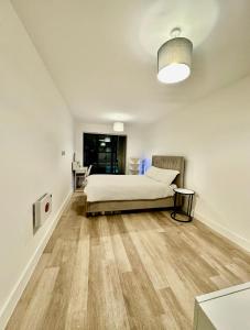 Un dormitorio con una cama y suelo de madera. en Digbeth Place - Birmingham City Centre, en Birmingham 3 fotos más