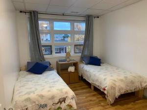 two beds in a room with a window at Four Seasons Garden in Whitehorse