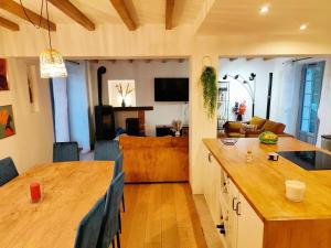 a kitchen and living room with a wooden counter top at Felicità - Longère with swimming pool and large garden in Poulaines