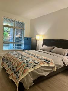 Modern 3-Bedroom Apartment in UBC في فانكوفر: غرفة نوم بسرير كبير ونافذة