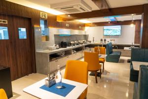 a restaurant with a table and chairs and a kitchen at Vasatee Kondapur in Kondapur