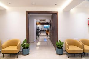 a waiting room with chairs and a corridor at Vasatee Kondapur in Kondapur
