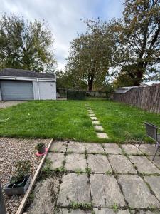 a backyard with a yard with a bench and grass at Bright Private Room with Parking & Garden Access in Spennymoor